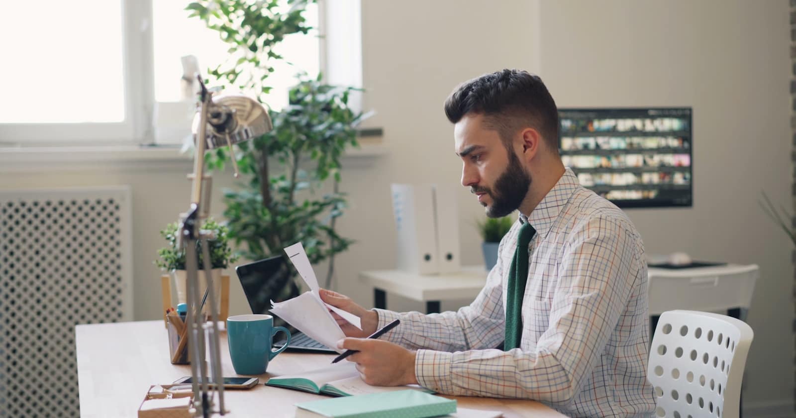 A person reviewing printed documents at a desk before signing