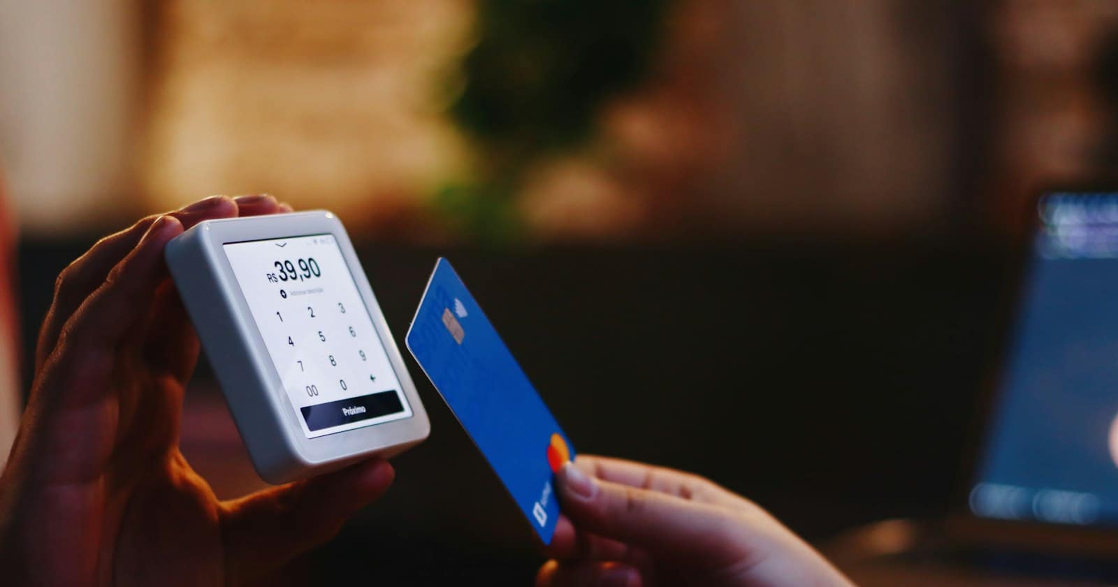 A customer paying on a phone with a card in hand while a chat conversation is open on the screen.