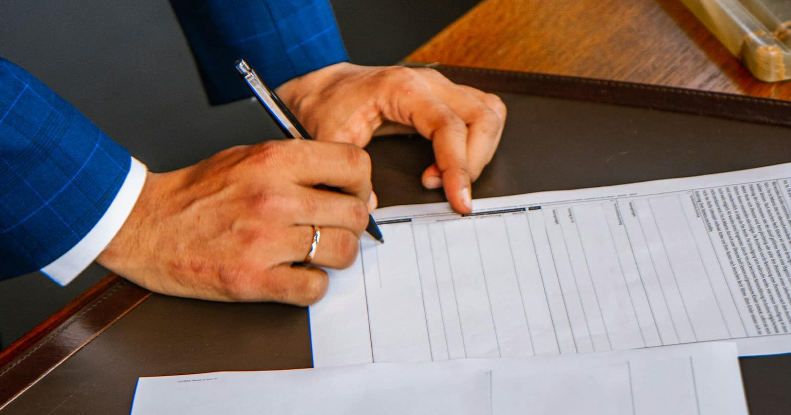Hands going through a row of filing folders, standing for the consent evidence a business has to retrieve on request.