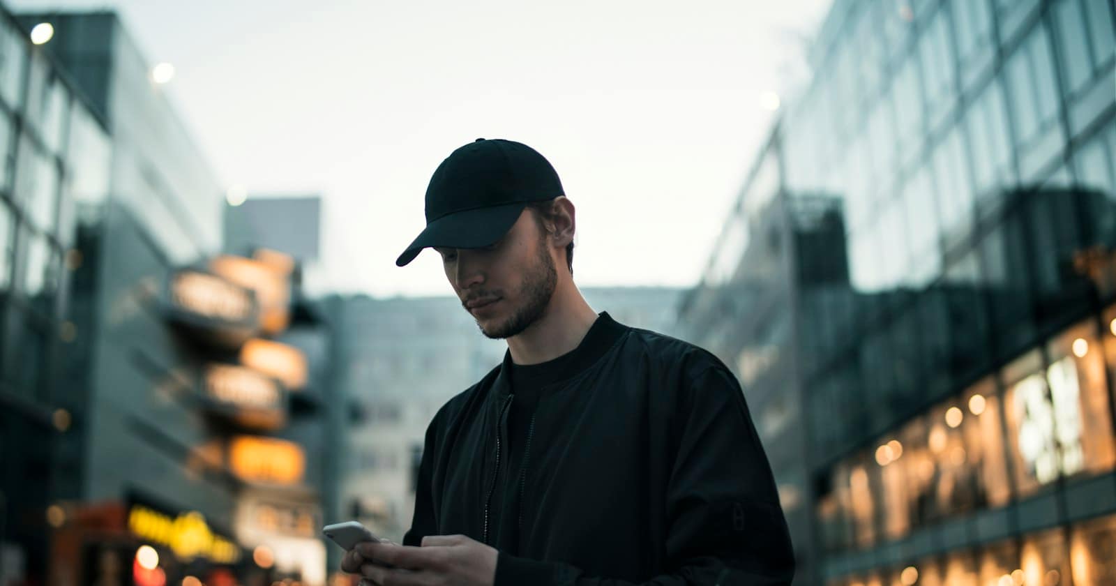 A person using a smartphone while walking through a city