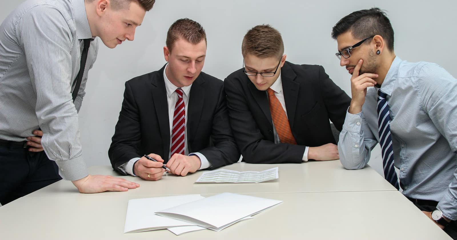 A printed contract on a desk with a pen resting on the signature line