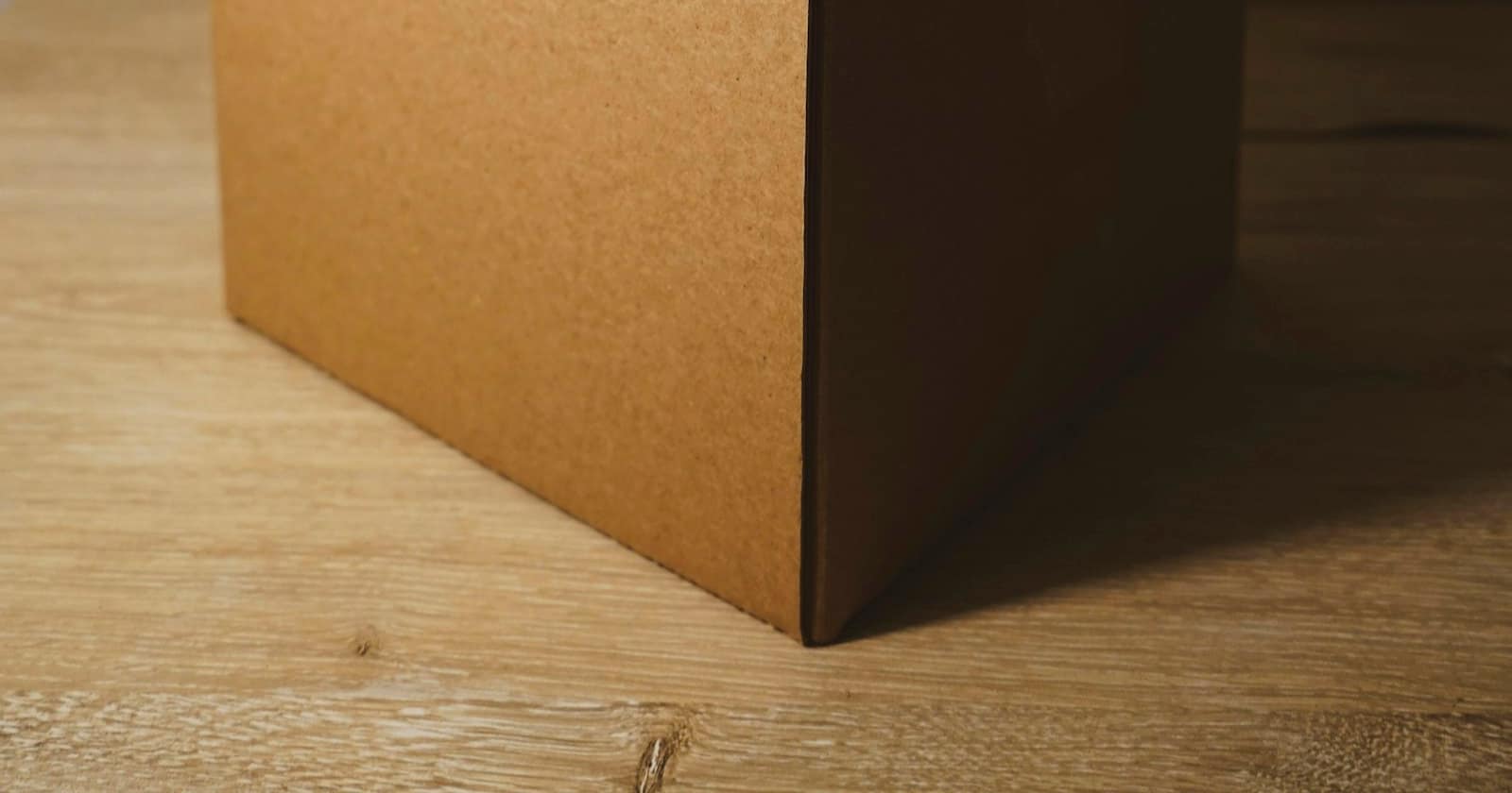 A customer packing an item back into its shipping box while checking their phone.