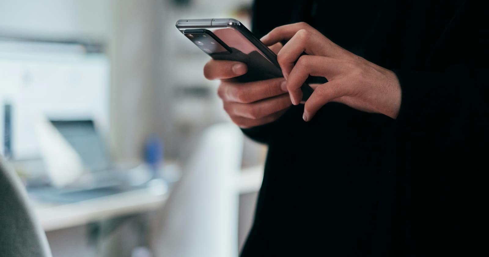Eine Hand hält ein Telefon mit einer Messaging-App