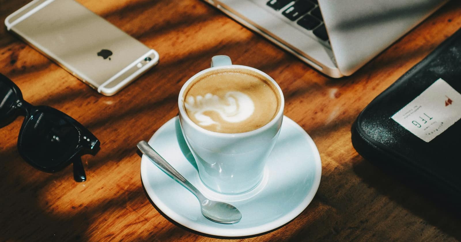 A morning coffee beside a phone on a desk