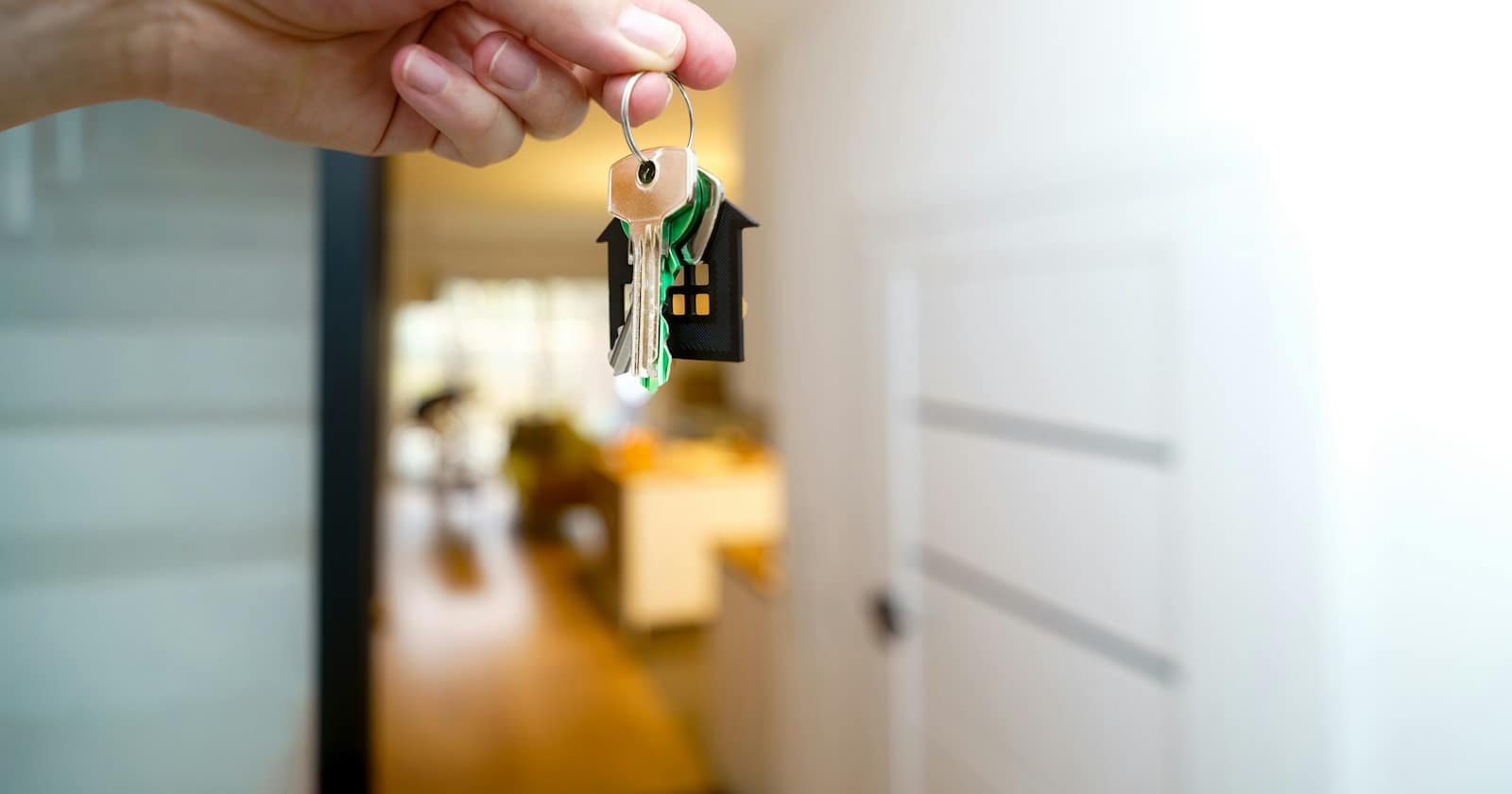 An estate agent showing a property listing on a phone to prospective buyers in an empty apartment.